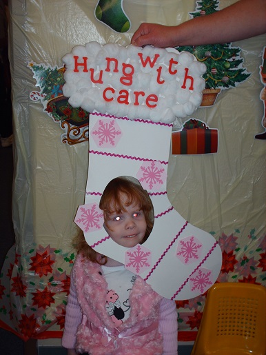 A little girl holding a sign that says hung with care